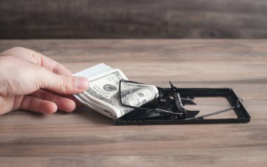 Fare kapanı ve dolar içinde bir erkek eli. Risk 