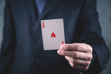 Takım elbiseli işadamı elinde iskambil kağıdı tutuyor..