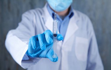 Kafkasyalı doktor elinde şırınga tutuyor. Enjeksiyon