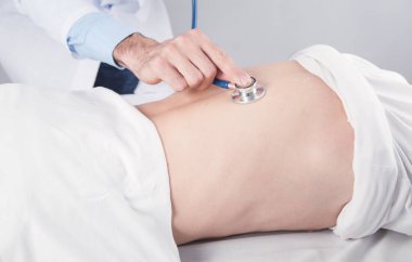 Doktor, hastanede steteskopla hastayı kontrol ediyor..