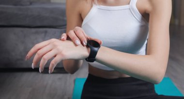 Evde akıllı saat kullanan bir kadın..