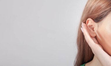 Kadın elini kulağına koyup dinliyor.. 