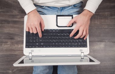 Evde dizüstü bilgisayar kullanan bir adam.