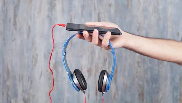 Hombre Sosteniendo Teléfono Inteligente Auriculares —  Fotos de Stock