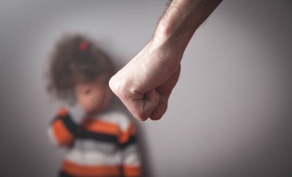 Злой мужской кулак. Маленькая девочка дома. Насилие в семье