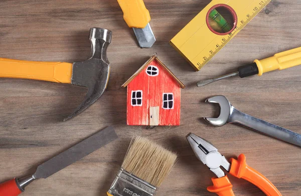 Ahşap bir ev modeliyle çalışma araçları.