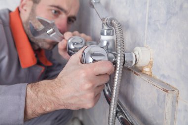 Banyodaki banyo musluğunu tamir edip tamir etmek..