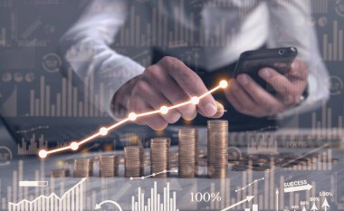 Man stacking coins with a graph of profit.	