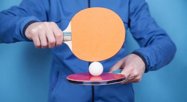 Tenis raketi ve beyaz plastik top tutan adam..