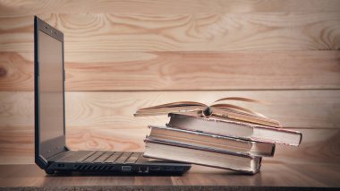 Kitaplar ve dizüstü bilgisayarlar ahşap masada..