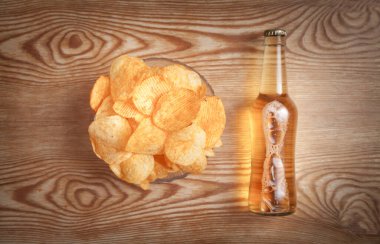 Tahta masada patates cipsi ve şişe bira..