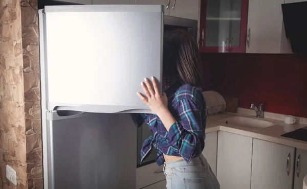 Kadın evinde buzdolabının kapısını açıyor..