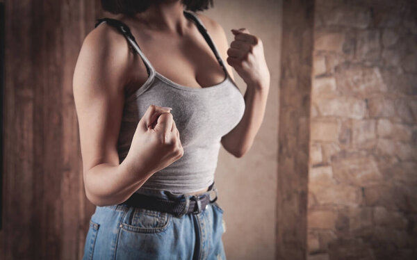 Кавказская молодая женщина угрожает кулаками дома.