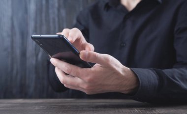 Beyaz iş adamı ofiste akıllı telefon kullanıyor..