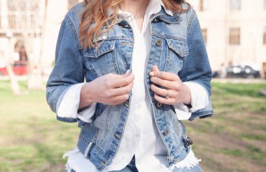 Kadın kot ceket düğmelerini ilikler..