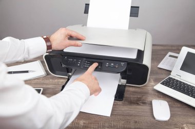 Ofiste belgeleri kopyalayan ve tarayan adam.