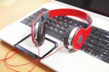 Laptop bilgisayar klavyesinde kulaklıklar.