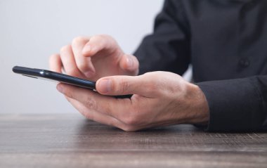 Beyaz iş adamı ofiste akıllı telefon kullanıyor..