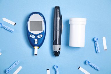 Test şeritleri ve diğer nesnelerle birlikte glukometre. Kandaki glikozu ölçmek için aygıtlar