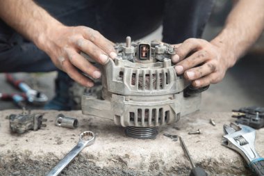 Adam araba alternatörünü tamir ediyor. Servis Merkezi