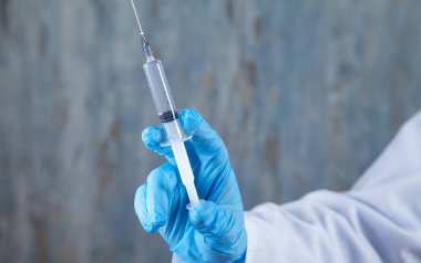 Kafkasyalı doktor elinde şırınga tutuyor. Enjeksiyon