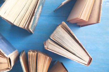 Mavi ahşap zemin üzerine eski kitaplar.