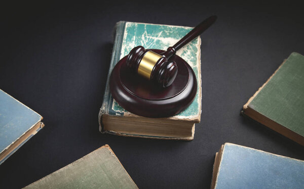 Judge gavel and book on the black background.