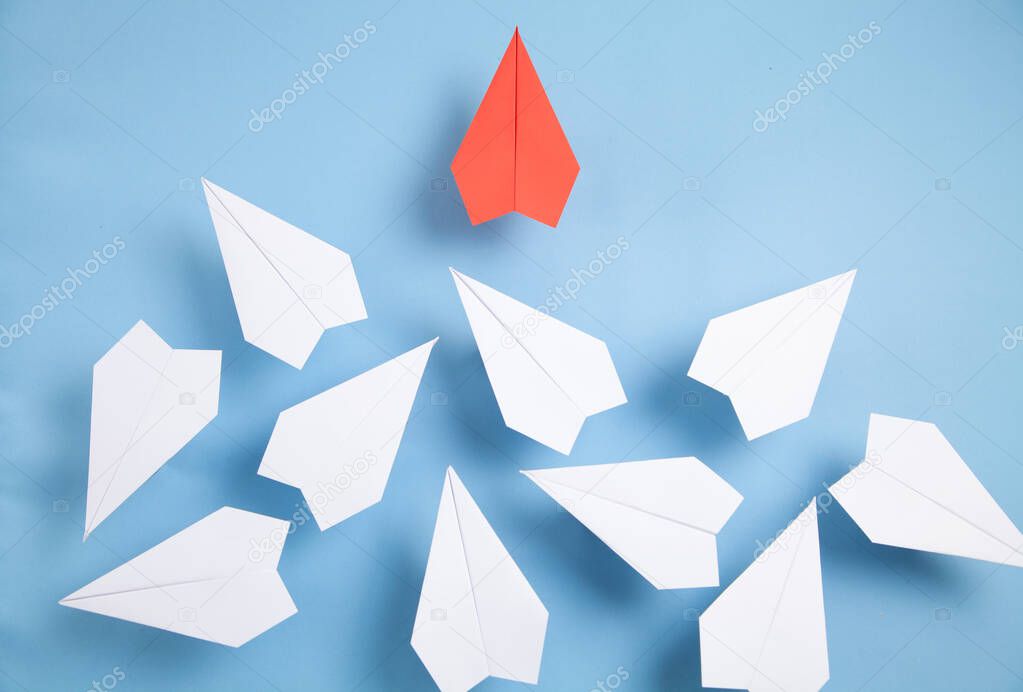 Red and white paper airplanes on blue background. Leadership. Teamwork