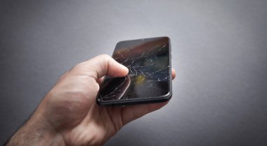 Elinde siyah bozuk akıllı telefon tutan adam. Kırık Ekran