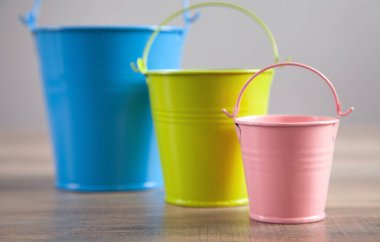 Masadaki pembe, mavi, yeşil kova..