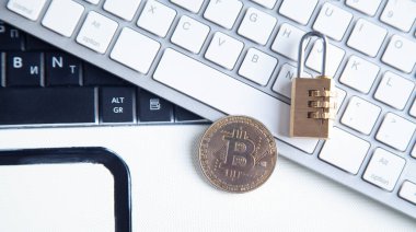 Beyaz bilgisayar klavyesinde bitcoin ve asma kilit. 