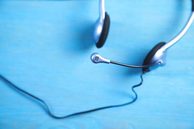 Mavi arka planda müşteri hizmetleri kulaklığı.