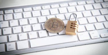 Beyaz bilgisayar klavyesinde bitcoin ve asma kilit. 