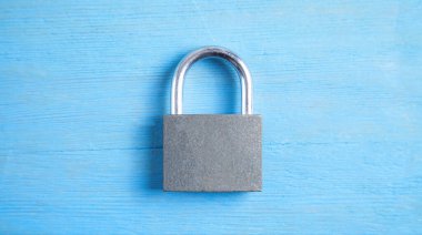 Mavi arkaplanda metal asma kilit.