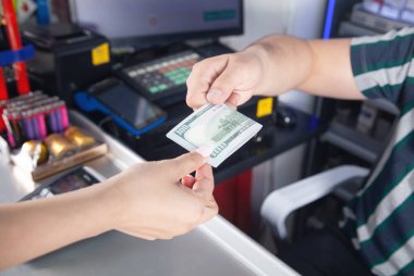 Genç bir kadın süpermarkette para ödüyor..