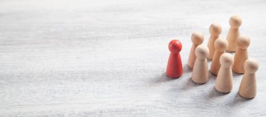 Beyaz masadaki tahta insan figürleri. Lider