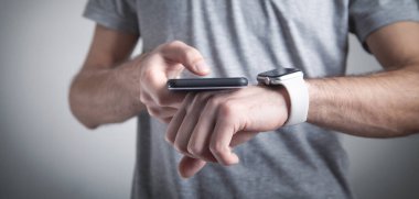 Akıllı saat ve akıllı telefon kullanan bir adam. Yaşam tarzı. Teknoloji