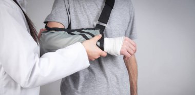 Kafkasyalı doktor hasta eline kol askısı takıyor..