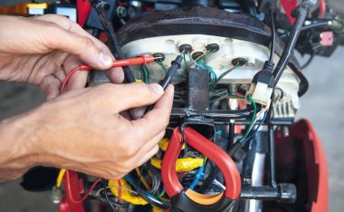 Tamirci, elektrik kablolarını bağlıyor..