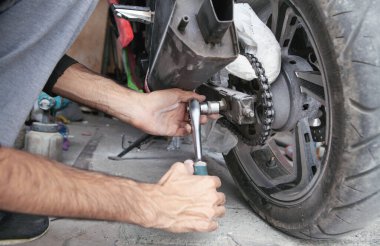 İngiliz anahtarı kullanan bir tamirci. Garajda motosikletle çalışıyorum.