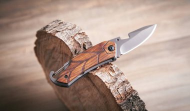 Kahverengi bıçak ve tahta arka planda bir ağaç dilimi..