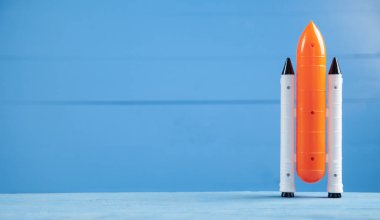 Mavi arka planda oyuncak uzay mekiği. Roket fırlatma 