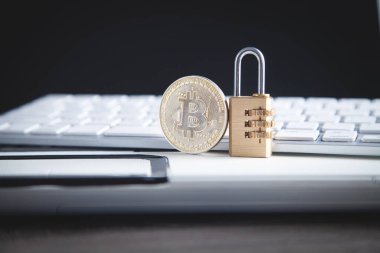 Beyaz bilgisayar klavyesinde bitcoin ve asma kilit. 