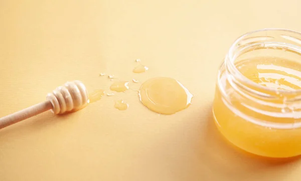 蜂蜜瓶とともに黄色の背景 — ストック写真