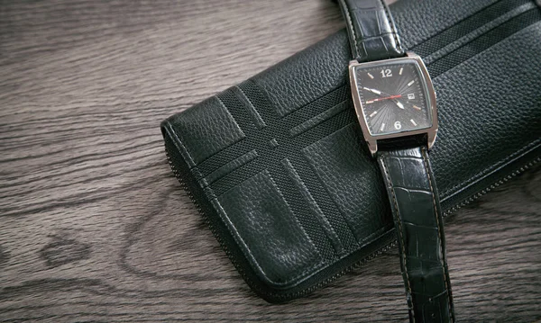 机の上に黒い腕時計と財布 — ストック写真