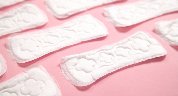 Менструальная подушка на розовом фоне.