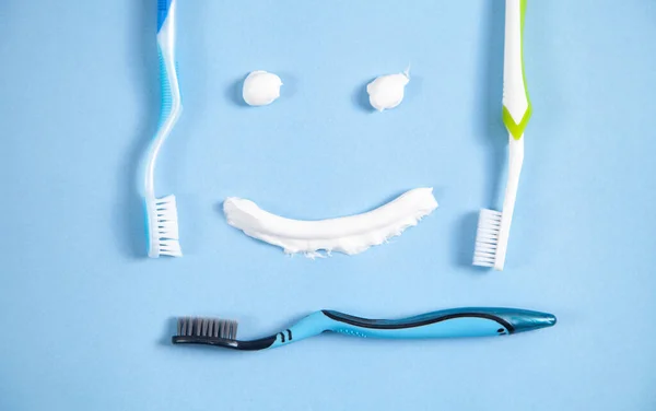 Zubní Kartáčky Modrém Pozadí Usměvavá Tvář — Stock fotografie