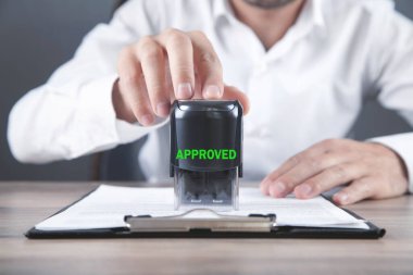 Belgeye onaylı damga basan adam.