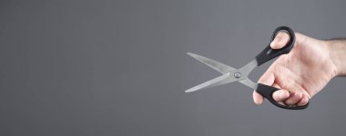 Siyah bir makas tutan erkek el..