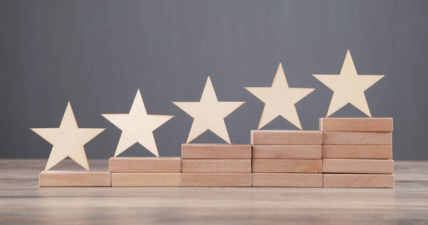 Wooden 5 stars on wooden block. Increase rating